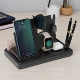 Multi-device charging station holding phone, watch, sunglasses, and pens on a desk.